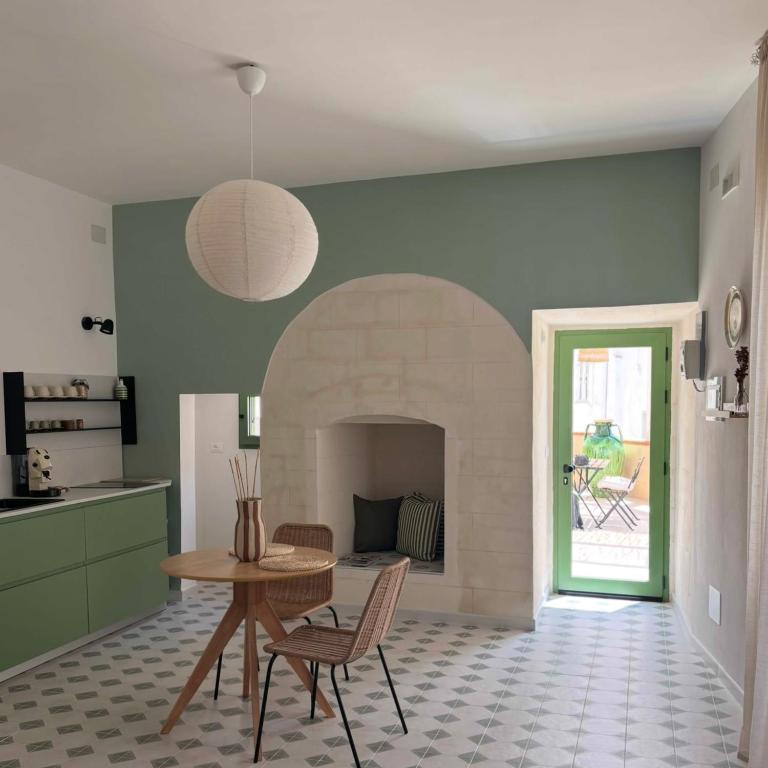 a kitchen and dining room with a table and a fireplace at B&B Casa Uliva in Castellaneta