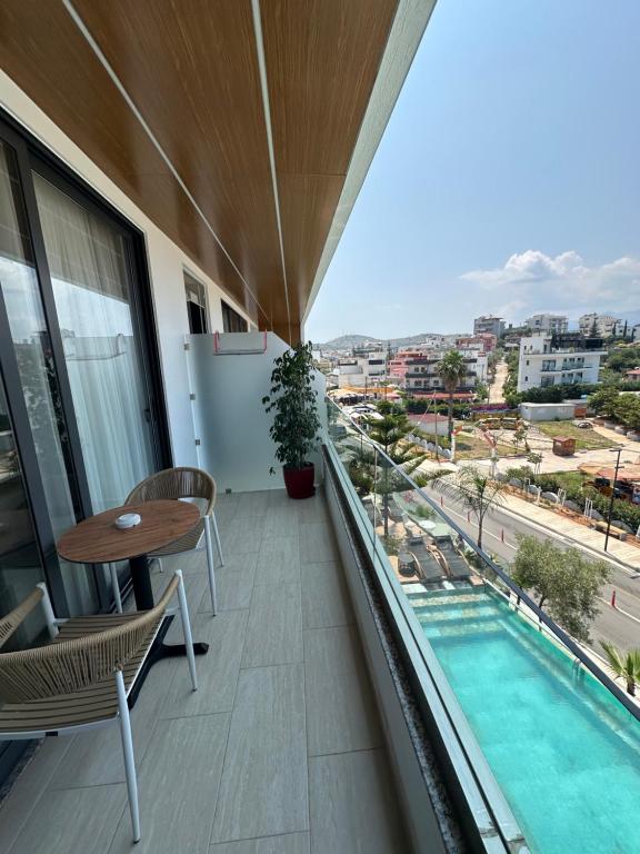 a balcony with a table and a swimming pool at Ilio Boutique Hotel in Ksamil