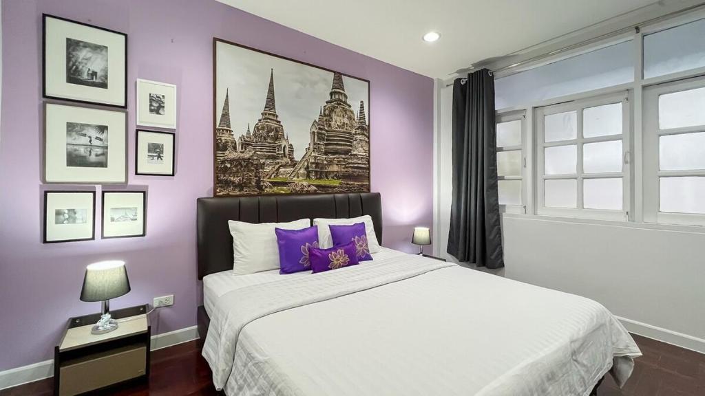 una camera da letto con un letto grande con pareti viola di BTS Asoke 6bedroom townhouse a Bang Kapi