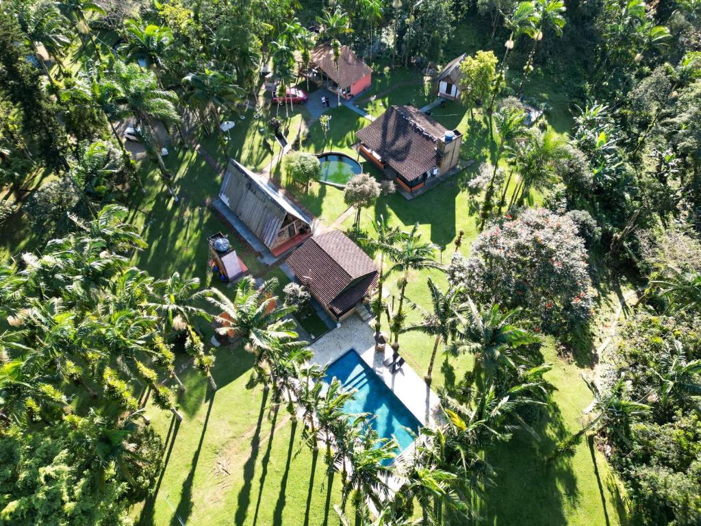 an aerial view of a resort with a pool and palm trees at Chácara bello Rio in Guaratuba