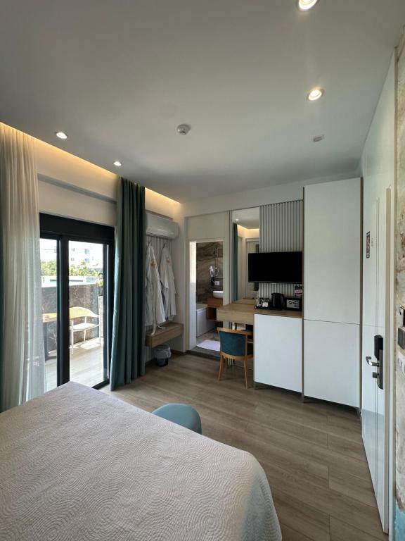 a bedroom with a bed and a room with a desk at Ilio Boutique Hotel in Ksamil