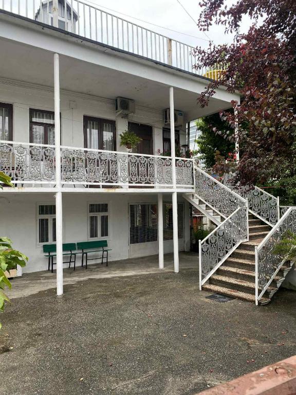 a building with a staircase and a green bench at tata's house in Kobuleti