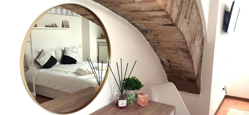 1 dormitorio con espejo grande en la pared en Appartamento Centro Storico - Perugia, centro, en Perugia