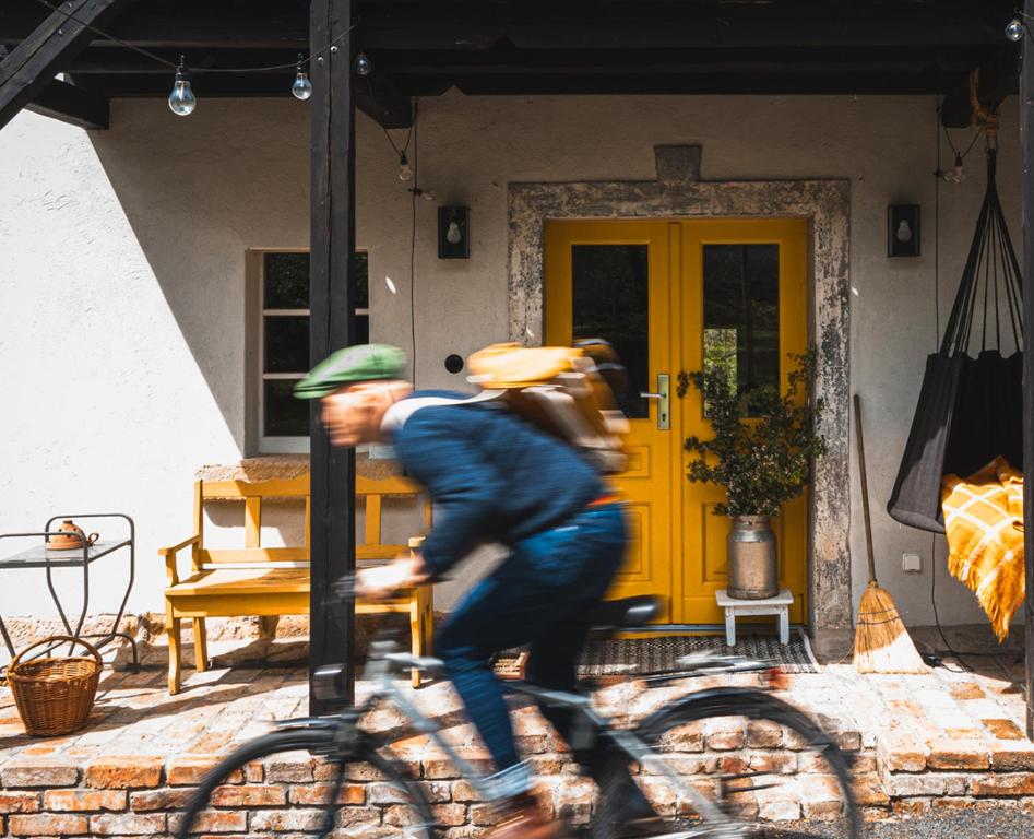 a man riding a bike in front of a house at Wietorówka in Lubomierz