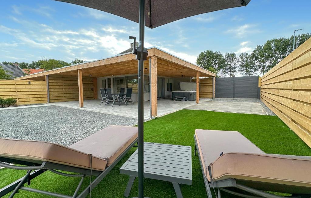 a backyard with two chairs and an umbrella at Oud Kempen Bungalow 7 in Stavenisse
