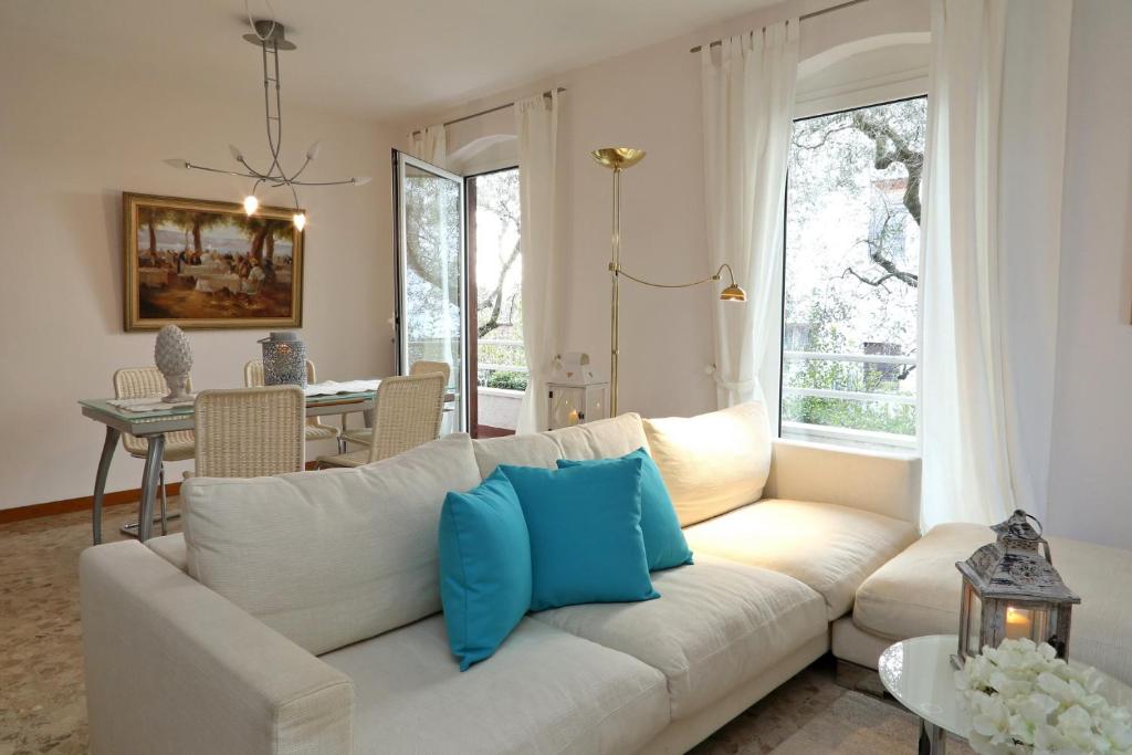 a living room with a white couch with blue pillows at Villa Linda Bardolino in Bardolino