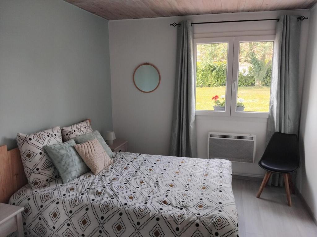 una camera da letto con un letto e una finestra di Maison pétanque piscine 2 à 6 personnes a Chevigny-en-Valière