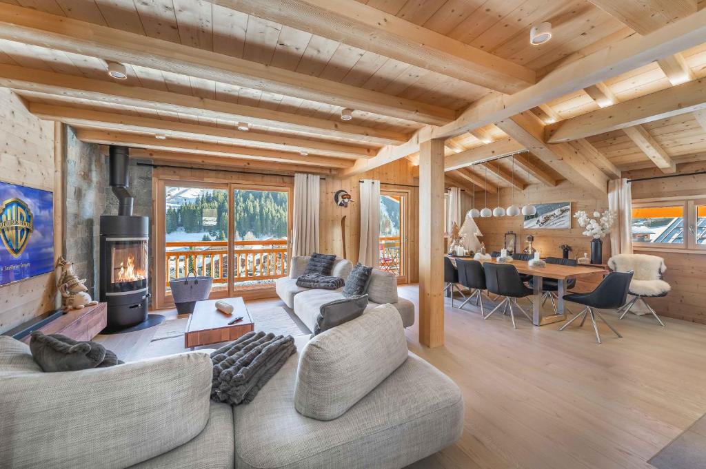 un salon avec deux canapés et une cheminée dans l'établissement 1/2 Chalet : douceur Alpine au Linga, à Châtel