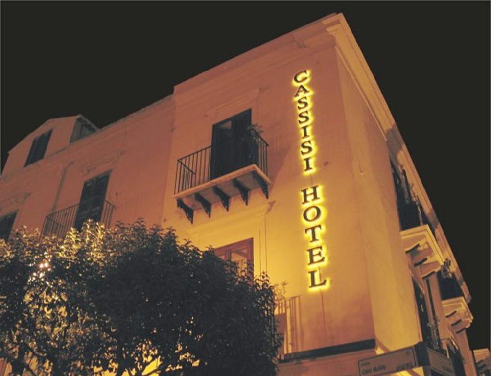 a building with a neon sign on the side of it at Cassisi Hotel in Milazzo