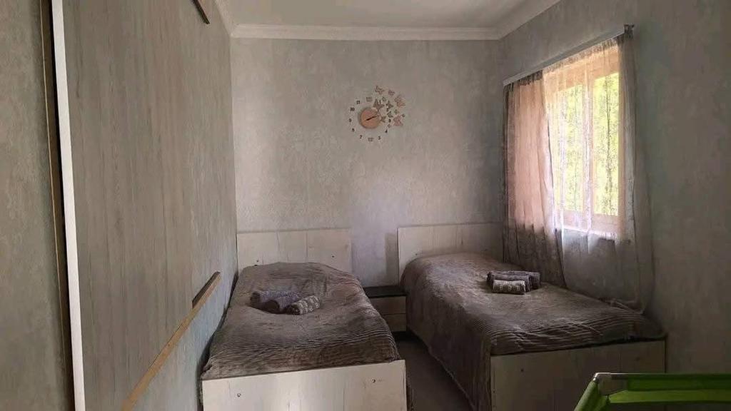 a small room with two beds and a window at Guest house Arabachyan in Aygut