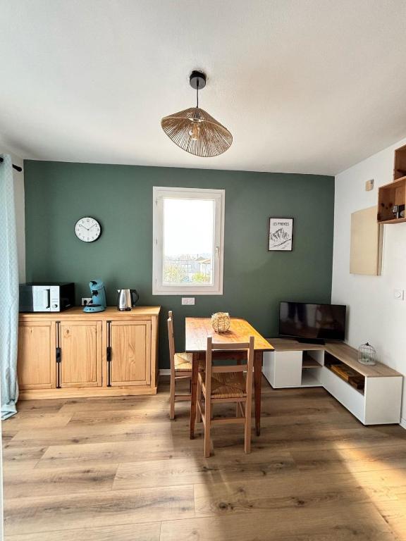 une cuisine avec une table et une salle à manger dans l'établissement Petit cocon avec terrasse, à Billère