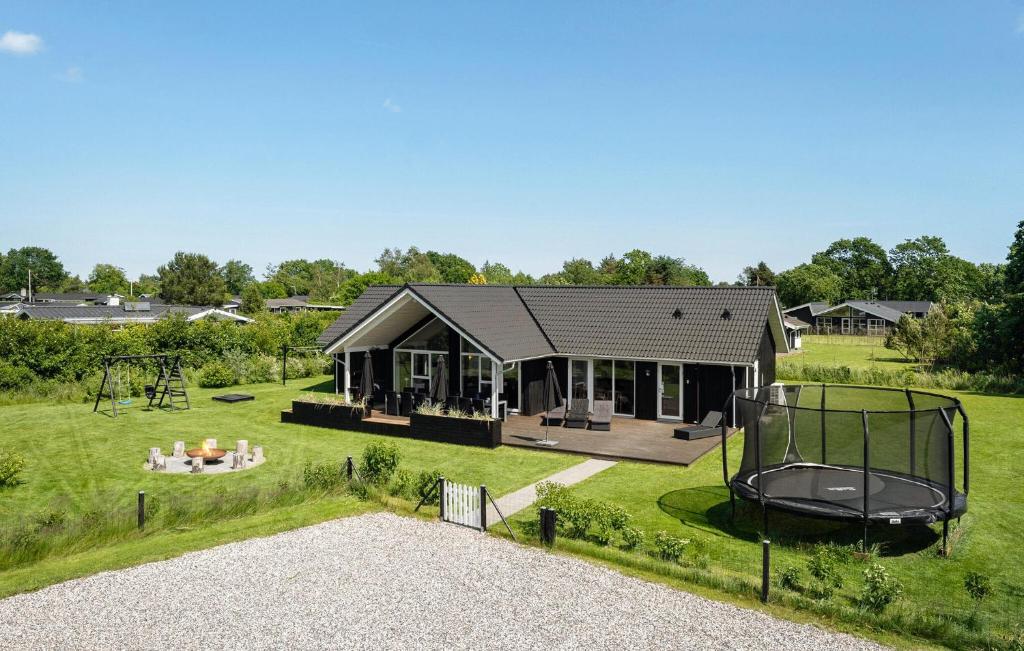une maison avec une aire de jeux dans la cour dans l'établissement Stunning Home In Hadsund With Sauna, à Hadsund