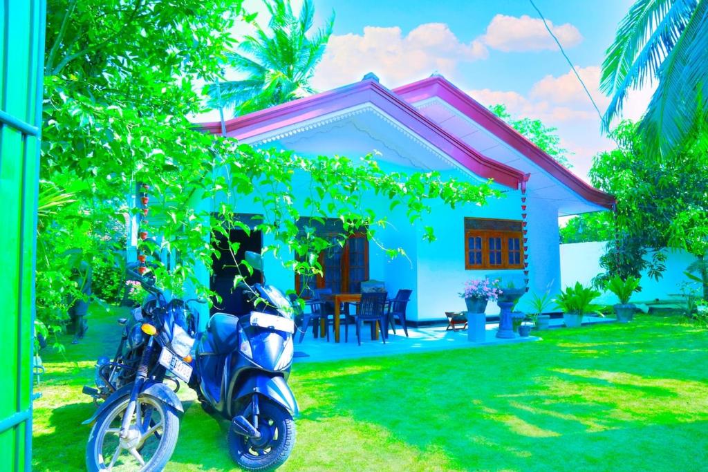 a blue motorcycle parked in front of a house at Villa Serenity Weligama in Weligama