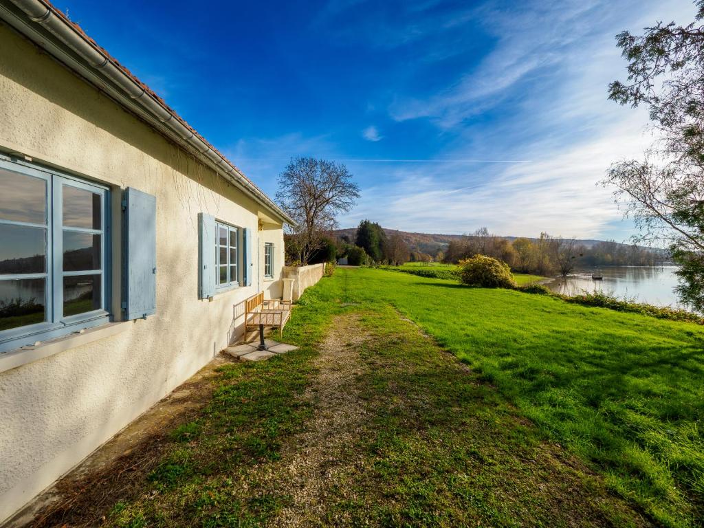 un bâtiment avec une fenêtre et un banc à côté d'un champ dans l'établissement Détente en Bord de Seine - Collection Idylliq, à Vétheuil