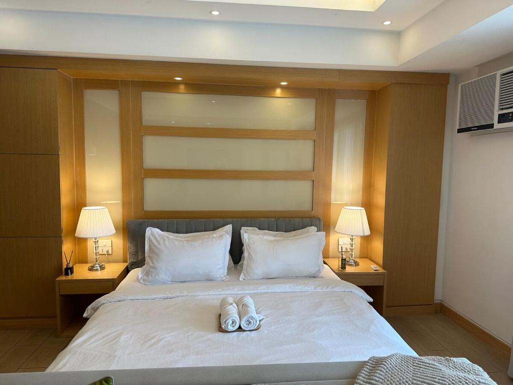 um quarto com uma cama com dois sapatos em cima em Amazing Sunrise Venice Grand Canal Balcony, Xbox Series X console with Game Pass Ultimate, FREE coffee, Pool, Gym & Sauna, 5 mins to BGC em Manilla