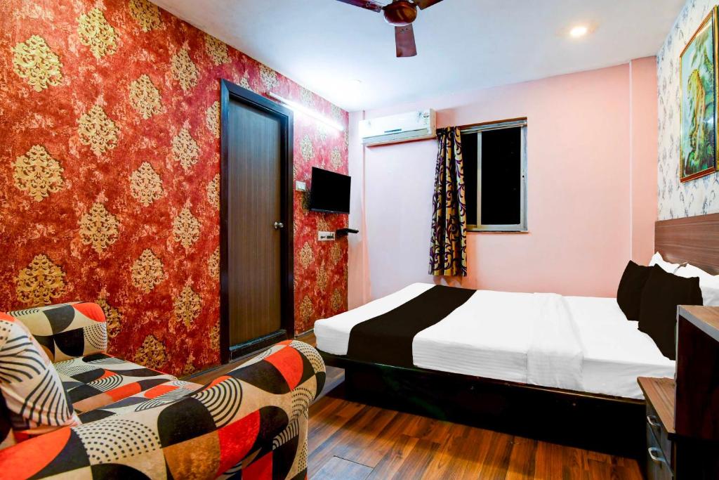 a bedroom with a bed and two chairs in it at Hotel O Circus Avenue Road in Kolkata