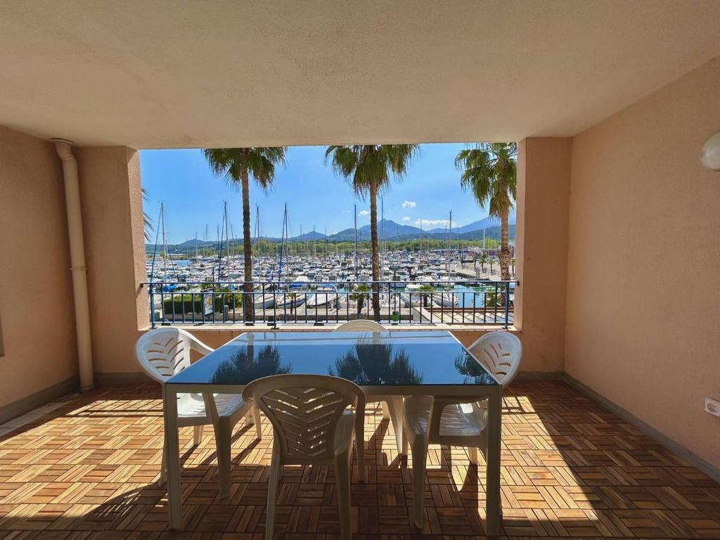 d'une table et de chaises sur un balcon avec vue sur le port. dans l'établissement Appartement moderne 4-6 pers, proche plage - Argelès-sur-Mer - FR-1-388-97, à Argelès-sur-Mer