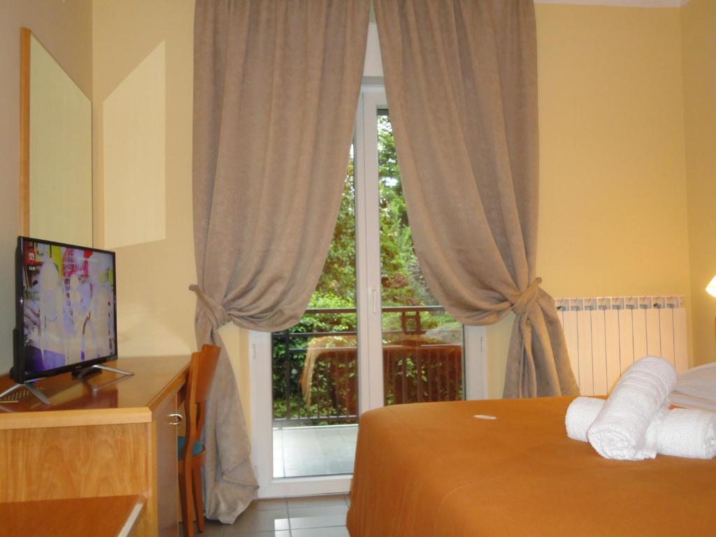 sypialnia z łóżkiem, telewizorem i oknem w obiekcie Hotel Arimannia w mieście Caramanico Terme