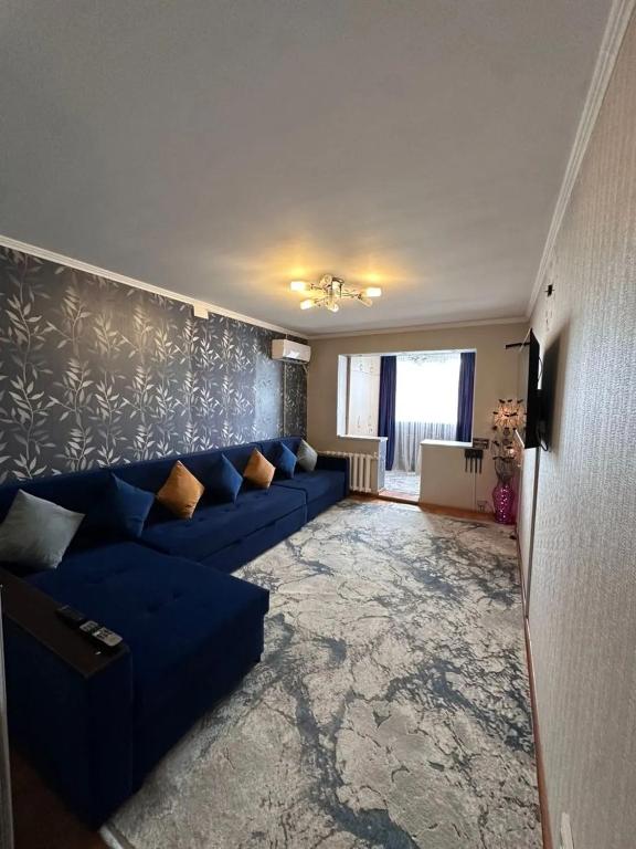 Una sala de estar con un sofá azul en una habitación. en 2-х комнатная квартира в 5 микрорайоне, en Bishkek