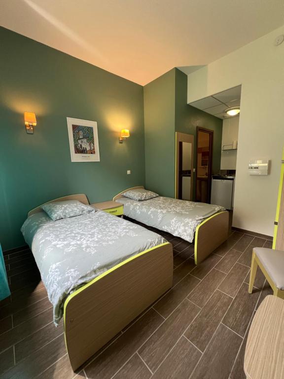 twee bedden in een kamer met groene muren bij Auberge Lou Poumié in Pierlas
