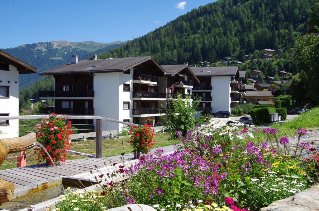 Una vista desde el balcón de un hotel con flores. en Résidence Arnica 3 pièces, en Nendaz