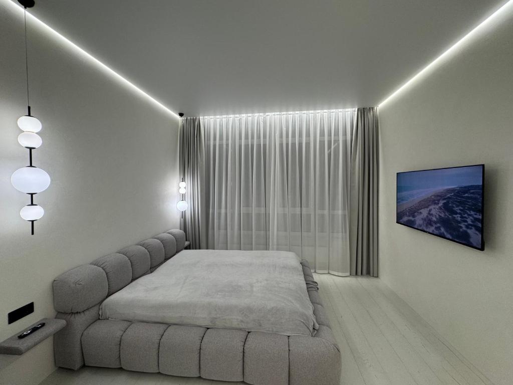 a white bedroom with a bed and a window at Аркадия ! ЖК Атмосфера ,панорама моря ,паркинг in Odesa