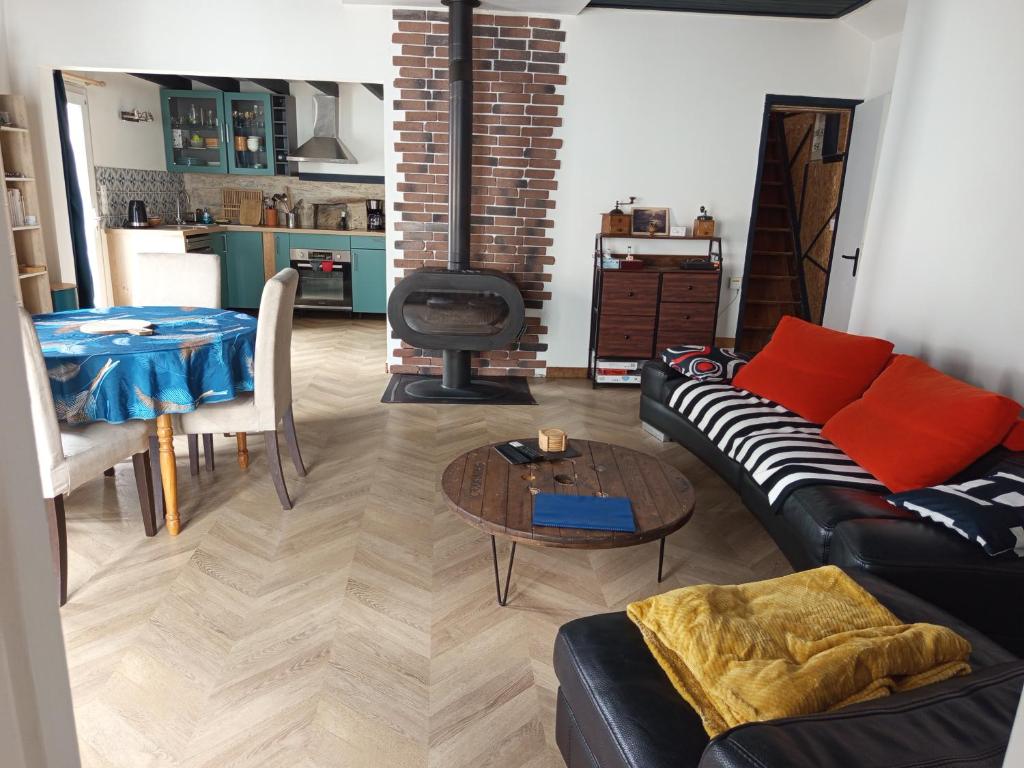 un salon avec un canapé noir et une table dans l'établissement L'escale du lac, à Saint-Julien-des-Landes