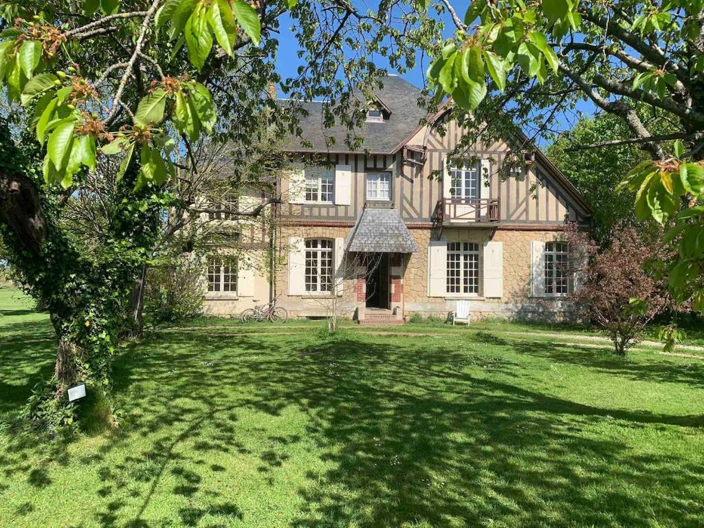 une grande maison en briques avec une grande pelouse dans l'établissement Grande maison normande de 250 m2 1ha - aperçu mer, à Auberville