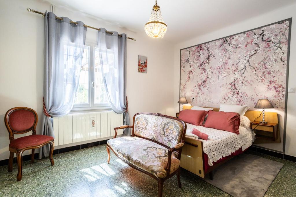 un dormitorio con una cama y una silla en Villa Philipp'inn, en Arles