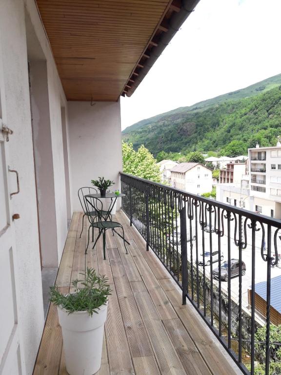 un balcon avec une table et une chaise sur un immeuble dans l'établissement AGREABLE T4 centre D'AX-LES-THERMES, à Ax-les-Thermes