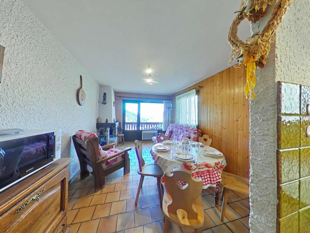 - un salon avec une table, des chaises et une télévision dans l'établissement Appt cosy 3 pièces avec cheminée, proche télécabine - FR-1-241-42, au Grand-Bornand