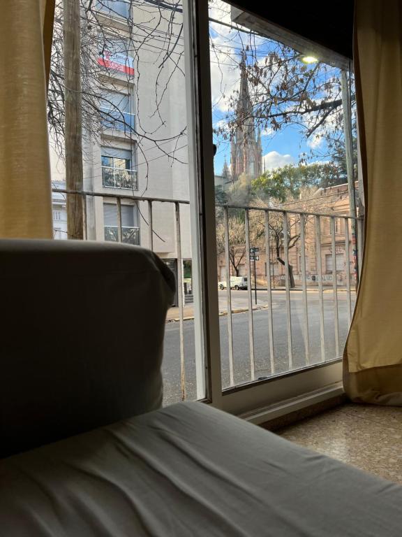 Un dormitorio con una ventana con vista a una iglesia. en Departamento 54, en La Plata
