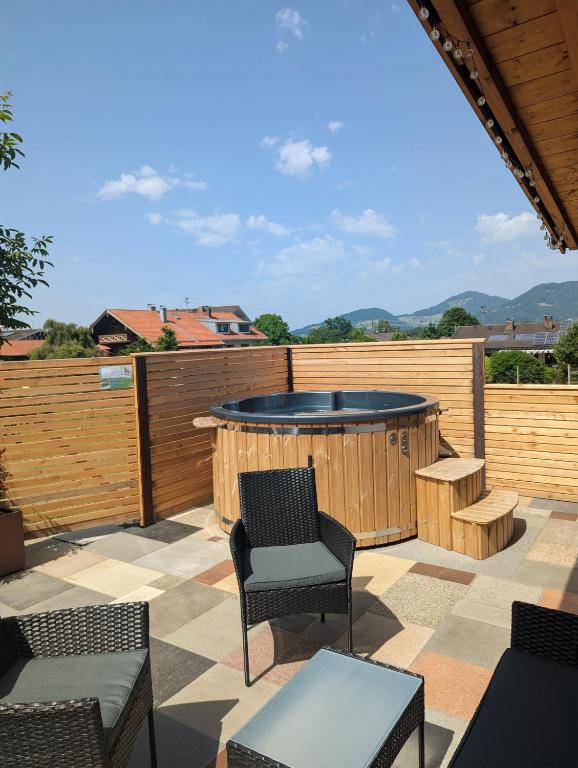 a patio with a hot tub and a table and chairs at Ferienwohnung Goasnstoi - mit HotTub und Bergblick im Inntal in Flintsbach am Inn