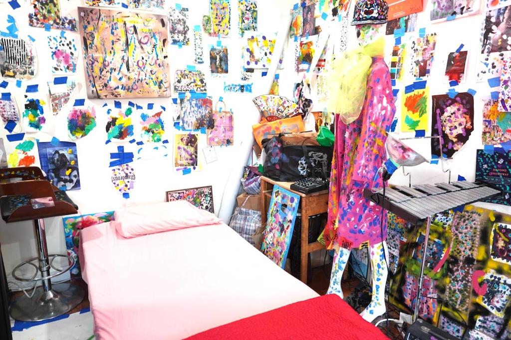 une chambre avec un lit et un mur avec des tableaux dans l'établissement Starry Art Room , West NY near NYC, à West New York