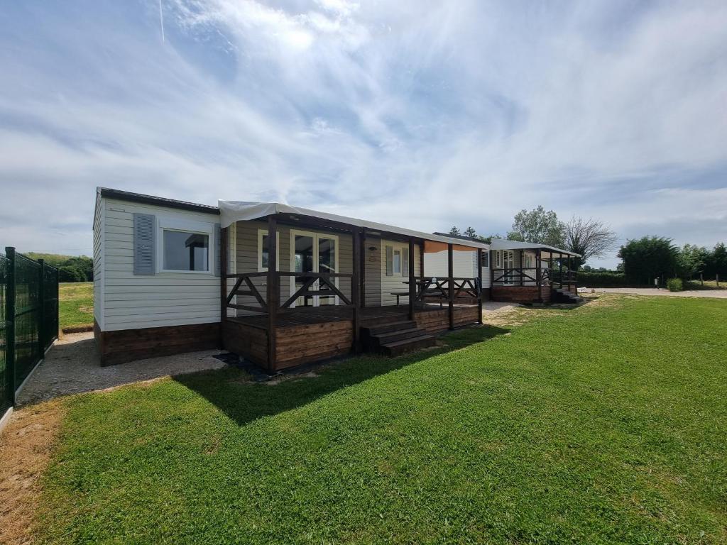 Ce mobile home dispose d'une terrasse couverte et d'une cour. dans l'établissement Camper au Moulin de la brevette, à Arbigny