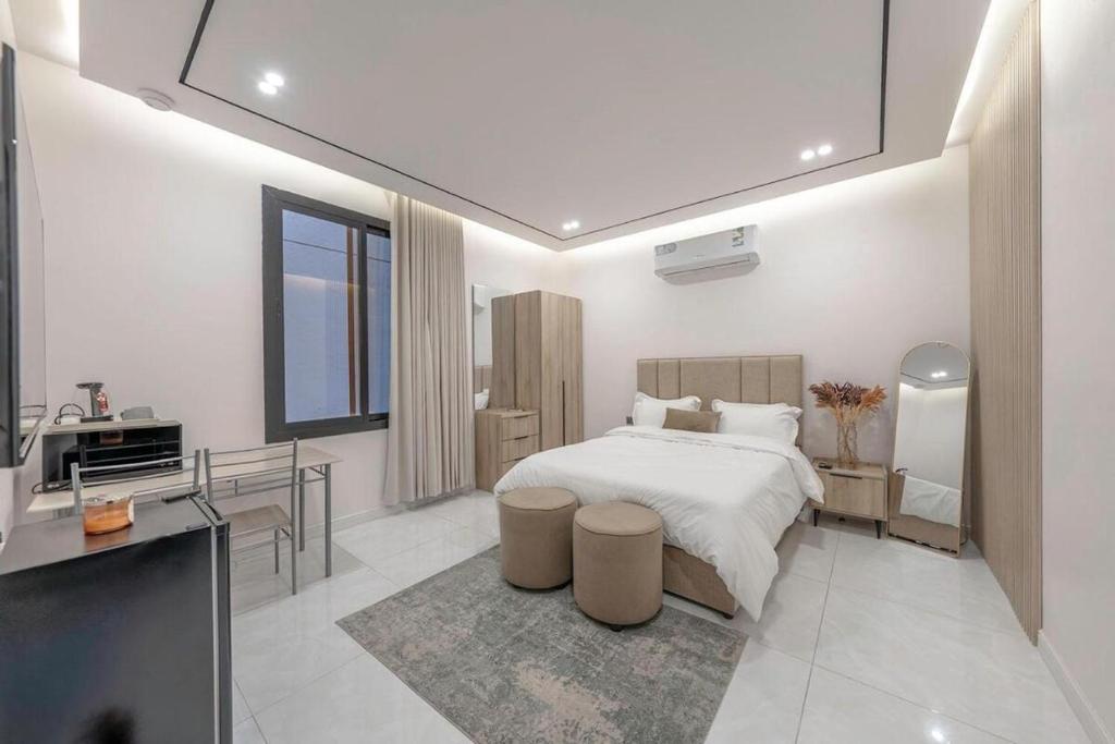 a bedroom with a bed and a desk and a sink at Alzahraa Studio in Jeddah