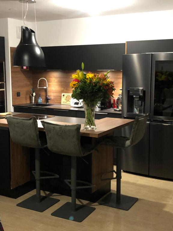 une cuisine avec une table avec un vase de fleurs dessus dans l'établissement Symphonie Sur Parc, à Hyères