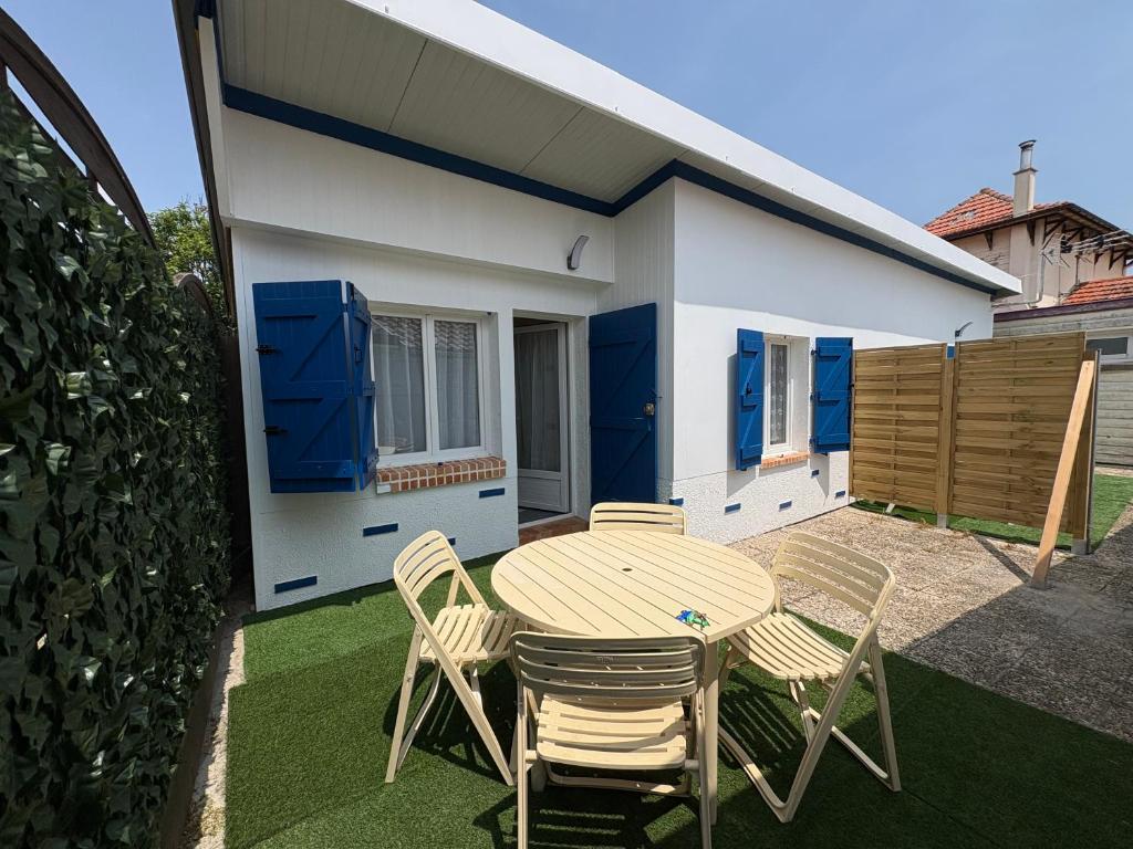 une table et des chaises devant une maison dans l'établissement Soleil et Sable, à Mimizan-Plage