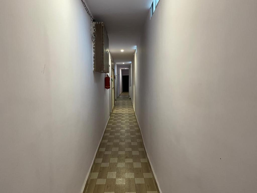 een lange hal met een witte muur en een tegelvloer bij Hotel star in Rānchī
