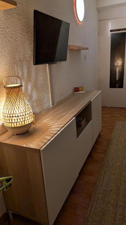 un comptoir avec un téléviseur en haut dans l'établissement La mer à deux, à La Grande Motte