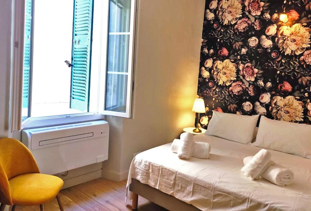 - une chambre avec un mur fleuri derrière un lit dans l'établissement Superb central apartment, air-conditioned, parking, à Saint-Tropez