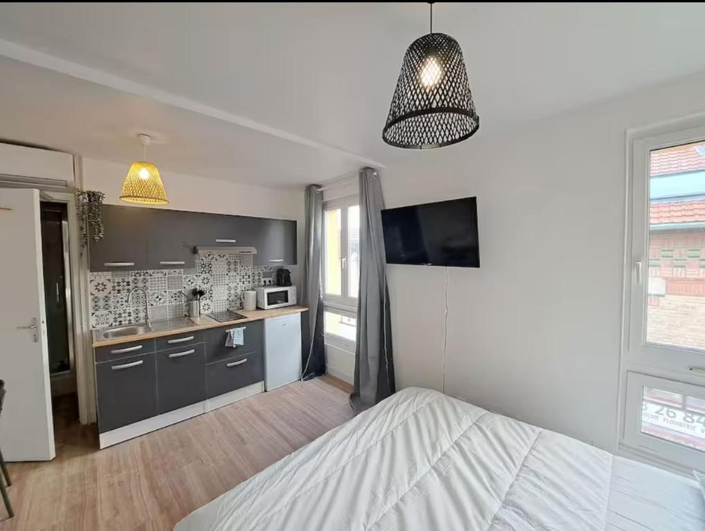 Il comprend une chambre avec un lit et une cuisine avec une télévision. dans l'établissement Bologne - 2 People - Paisible- Centre-ville, à Reims