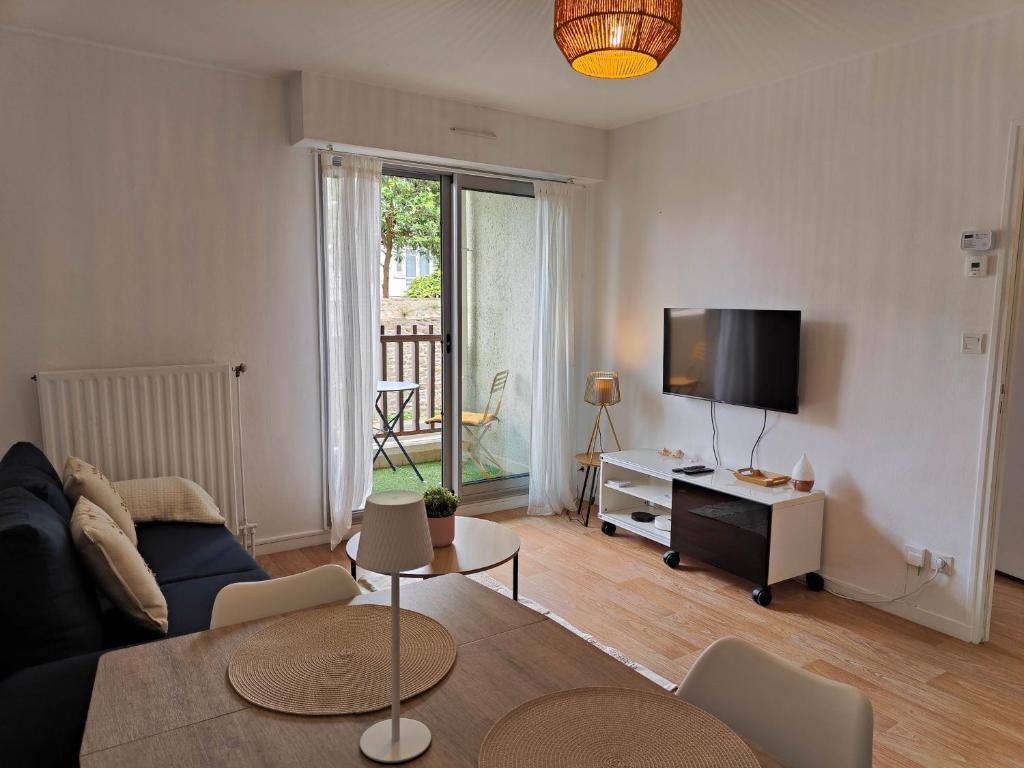 un salon avec un canapé et une télévision dans l'établissement La Frégate, à Saint-Malo