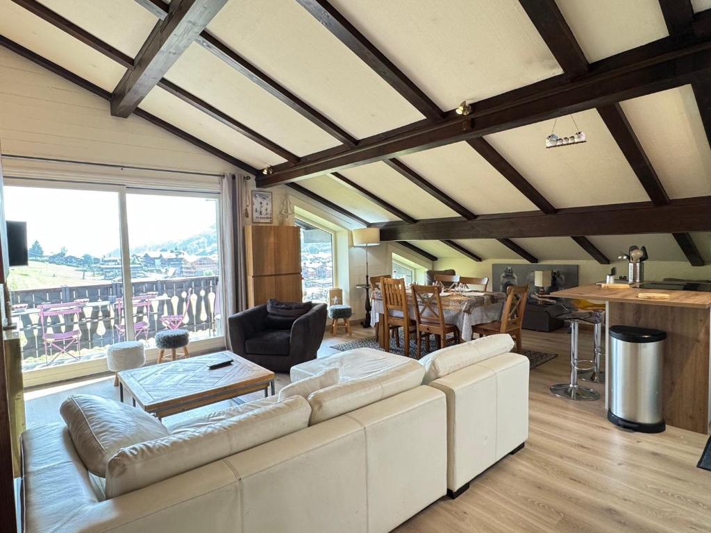 un salon avec un canapé blanc et une table dans l'établissement Appartement cosy avec balcon, wifi et garage aux Gets - FR-1-623-159, aux Gets