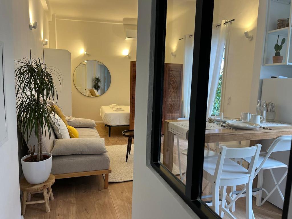 une cuisine et un salon avec une table et des chaises dans l'établissement Charmant T1 en centre-ville de Juan Les Pins, à Antibes