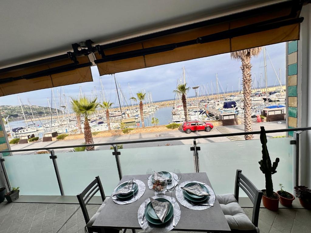 a dining table with a view of a marina at Marina dei Sogni Bilocale - Fronte mare con parcheggio gratuito e aria condizionata in San Lorenzo al Mare