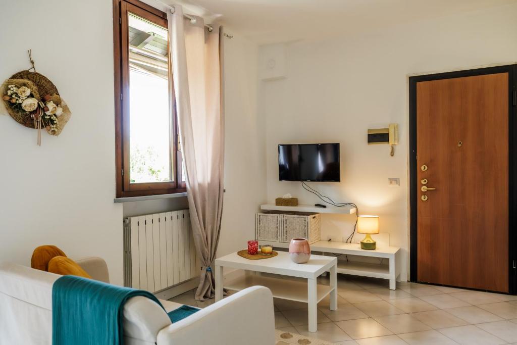 a living room with a white couch and a tv at Appartamento Dolce Casa 2 in  Monvalle 