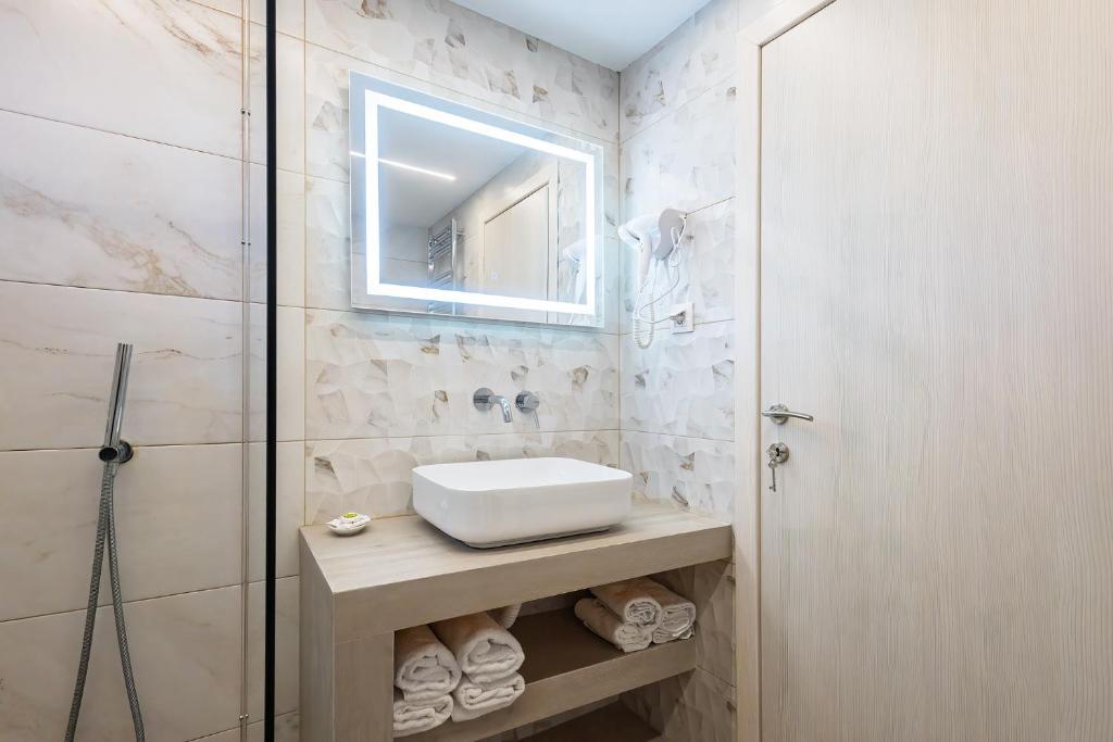 łazienka z umywalką i lustrem w obiekcie Kallikratia Suites 1 w miejscowości Nea Kallikratia