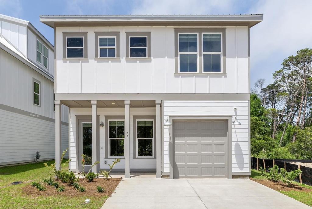 a white house with a garage at 3Zs Beach House 30A Sleeps 10! in Inlet Beach