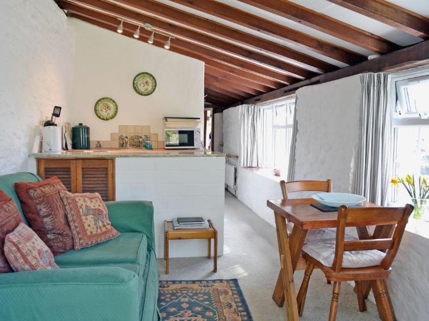 ein Wohnzimmer mit einer grünen Couch und einem Tisch in der Unterkunft Yarde cottage rural Devon Dog friendly in Membury